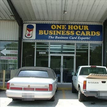 The One Hour Business Cards storefront sign, 'The Business Card Experts!', above the entrance at 3508 Chimney Rock